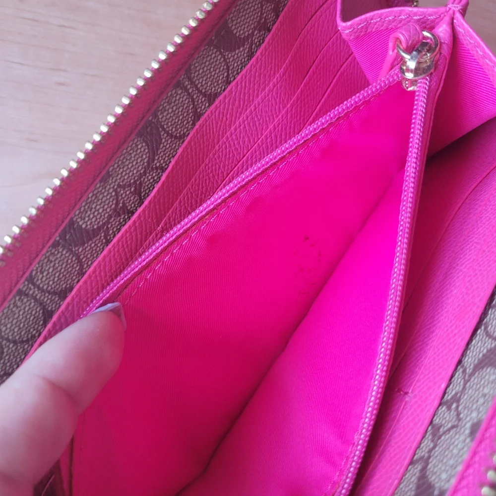 Coach Pink Leather Wallet with Gold Logo and Zip Closure.